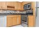 Kitchen with wood cabinets, granite countertops, and stainless steel appliances at 3300 Fox Chase N Cir # 231, Palm Harbor, FL 34683