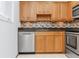 Kitchen features wood cabinets, granite countertops, stainless steel appliances, and tile backsplash at 3300 Fox Chase N Cir # 231, Palm Harbor, FL 34683