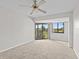 Bright bedroom with golf course views, ceiling fan, and sliding glass door to balcony at 1933 Golfview Dr # 1933, Tarpon Springs, FL 34689
