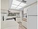 Condo kitchen with white cabinets, appliances, and wood-look floors at 1933 Golfview Dr # 1933, Tarpon Springs, FL 34689