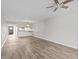 Open living room with wood-look floors, ceiling fan and kitchen view at 1933 Golfview Dr # 1933, Tarpon Springs, FL 34689