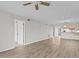 Open living room with wood-look floors, ceiling fan, and view to kitchen at 1933 Golfview Dr # 1933, Tarpon Springs, FL 34689