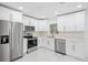 Modern kitchen with white cabinets, stainless steel appliances, and marble flooring at 5530 & 5530 1/2 7Th N Ave, St Petersburg, FL 33710