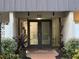 Condo building entrance with double doors, address number, and landscaping at 4606 W Gray St # 205, Tampa, FL 33609