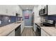 Bright kitchen boasts stainless steel appliances and blue tile backsplash at 8911 Blind Pass Rd # 305, St Pete Beach, FL 33706