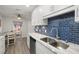 Updated kitchen with white cabinets, granite countertops, and stylish blue tile backsplash at 8911 Blind Pass Rd # 305, St Pete Beach, FL 33706