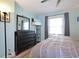 Main bedroom with dresser, large bed and window with curtains at 5134 Salmon Se Dr # A, St Petersburg, FL 33705