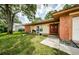 Brick home exterior featuring a double door entry and well-manicured lawn at 2208 Citrus Valley Cir, Palm Harbor, FL 34683