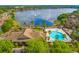Aerial view of community pool, clubhouse, and lake at 9028 Lake Chase Island Way, Tampa, FL 33626