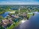 Aerial view of a townhome community with a lake; the subject property is a teal-colored building at 9028 Lake Chase Island Way, Tampa, FL 33626