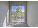 Bedroom with sliding glass doors leading to a balcony overlooking nature at 9028 Lake Chase Island Way, Tampa, FL 33626