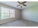 Well-lit bedroom with grey carpet and a large window at 9028 Lake Chase Island Way, Tampa, FL 33626