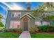 Green two-story townhome with a charming front entrance at 9028 Lake Chase Island Way, Tampa, FL 33626