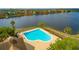Community pool with lake view and surrounding landscape at 9028 Lake Chase Island Way, Tampa, FL 33626