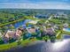Aerial view of a townhome community with a lake; the subject property is a teal-colored building at 9028 Lake Chase Island Way, Tampa, FL 33626