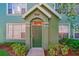 Green two-story townhome with a welcoming front door and landscaping at 9028 Lake Chase Island Way, Tampa, FL 33626