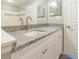 Bathroom with granite countertops, white cabinets and double sinks at 9028 Lake Chase Island Way, Tampa, FL 33626