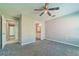 Bedroom with grey carpet, ceiling fan and ensuite bathroom access at 9028 Lake Chase Island Way, Tampa, FL 33626