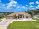 Tan house with brown roof, double garage, and landscaping at 10177 Sunburst Ct, Spring Hill, FL 34608