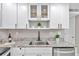 White cabinets, granite countertops, and stainless steel sink at 650 Pinellas Point S Dr # 106, St Petersburg, FL 33705
