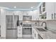 Modern kitchen with stainless steel appliances and white cabinets at 650 Pinellas Point S Dr # 106, St Petersburg, FL 33705