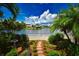 Landscaped backyard with stone path, bird bath, and peaceful lake view at 903 San Carlos Ne Ave, St Petersburg, FL 33702