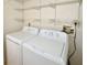 Well-lit laundry room with washer and dryer and ample shelving at 903 San Carlos Ne Ave, St Petersburg, FL 33702