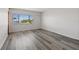 Simple bedroom with large window and grey laminate floors at 320 Windrush Blvd # 4, Indian Rocks Beach, FL 33785