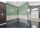 Formal dining room with dark hardwood floors and green accent wall at 5204 New Brittany Ln, Zephyrhills, FL 33541