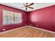 Bedroom with hardwood floors, ceiling fan and burgundy walls at 5204 New Brittany Ln, Zephyrhills, FL 33541