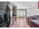 Kitchen with dark wood cabinets, black appliances, and tile flooring at 5204 New Brittany Ln, Zephyrhills, FL 33541