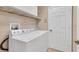 Convenient laundry room with washer, dryer, and overhead shelving at 5204 New Brittany Ln, Zephyrhills, FL 33541