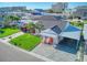 Single-story home with gray roof, orange door and paved driveway at 142 Beach Ave, Redington Shores, FL 33708