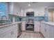 Well-equipped kitchen with stainless steel appliances and white cabinetry at 142 Beach Ave, Redington Shores, FL 33708