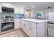 Modern kitchen with white cabinets, stainless steel appliances, and a breakfast bar at 142 Beach Ave, Redington Shores, FL 33708
