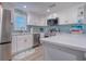 Modern kitchen with white cabinets, stainless steel appliances and quartz countertops at 142 Beach Ave, Redington Shores, FL 33708