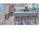 Kitchen features a breakfast bar with three stools and stainless steel appliances at 142 Beach Ave, Redington Shores, FL 33708