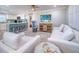 Bright living room with white sofas and a large TV at 142 Beach Ave, Redington Shores, FL 33708