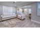 Living room with light colored sofa and armchair, and gray wood-look flooring at 142 Beach Ave, Redington Shores, FL 33708