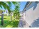 Side yard with a brick pathway, palm trees, and green grass at 142 Beach Ave, Redington Shores, FL 33708