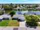 An aerial view of a single Gathering home on a canal with lush landscaping at 2248 Society Dr, Holiday, FL 34691