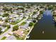 Aerial view of a canal front property with lush landscaping and nearby homes at 2248 Society Dr, Holiday, FL 34691
