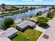 An aerial view of a waterfront home with a canal and neighboring houses at 2248 Society Dr, Holiday, FL 34691