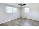 Spacious bedroom with ceiling fan and grey vinyl flooring at 2248 Society Dr, Holiday, FL 34691