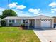 Charming single story home with a well-manicured lawn and attached garage at 2248 Society Dr, Holiday, FL 34691