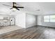 Living room features grey vinyl flooring, white walls, and ceiling fan at 2248 Society Dr, Holiday, FL 34691