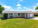 Ranch-style home with a gray exterior, attached garage, and manicured lawn at 2248 Society Dr, Holiday, FL 34691