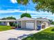 Exterior view of a single-story house with a two-car garage at 2248 Society Dr, Holiday, FL 34691