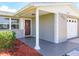 Inviting front entrance with a reddish-brown door, white columns, and neatly landscaped area at 2248 Society Dr, Holiday, FL 34691