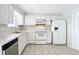 White kitchen with stainless steel appliances and tile floor at 2248 Society Dr, Holiday, FL 34691